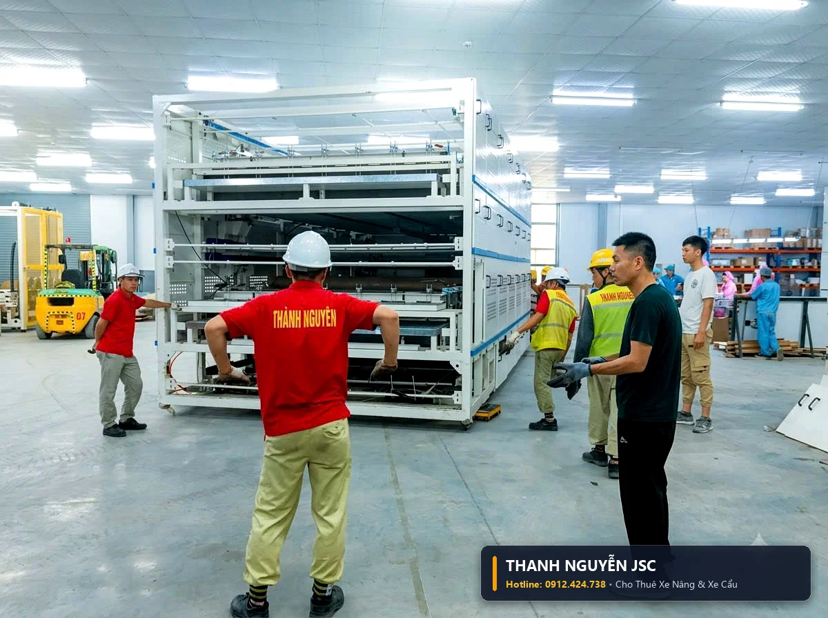 Kỹ sư an toàn THÀNH HUY HOÀNG tại Quảng Ninh áo đỏ hướng dẫn xe nâng di chuyển cụm khung giàn máy tự động nhiều tầng