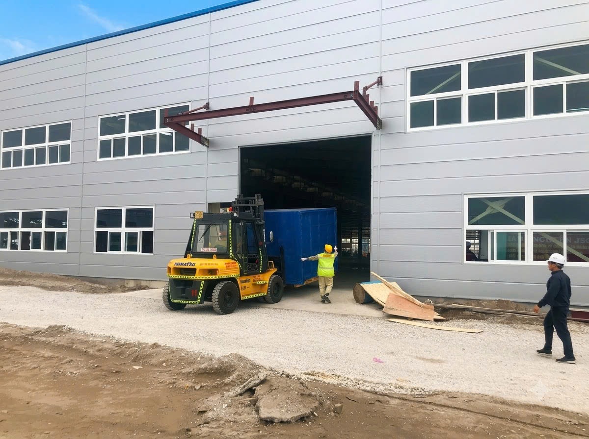 xe nâng Komatsu 7 tấn vận chuyển kiện máy móc luồn qua cửa kho xưởng tiền chế mới tại KCN Đông Mai Quảng Ninh - THÀNH HUY HOÀNG